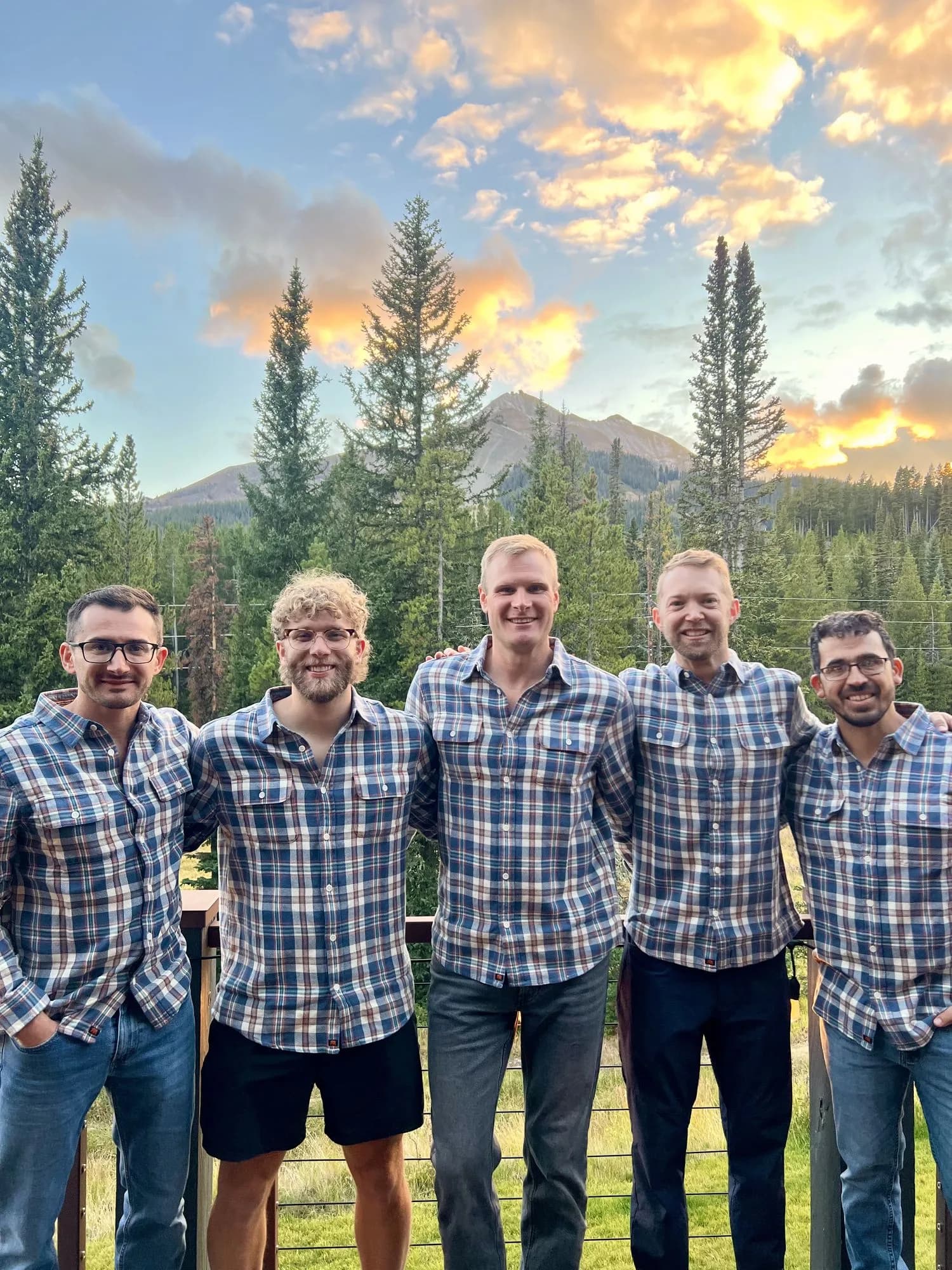 The Intentional Living FP team standing together on a mountain deck at sunset